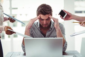 man krijgt stress aanval achter zijn laptop